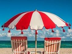 aan het strand met rood witte parasol